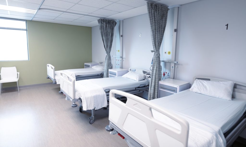 General view of an empty hospital room with three beds